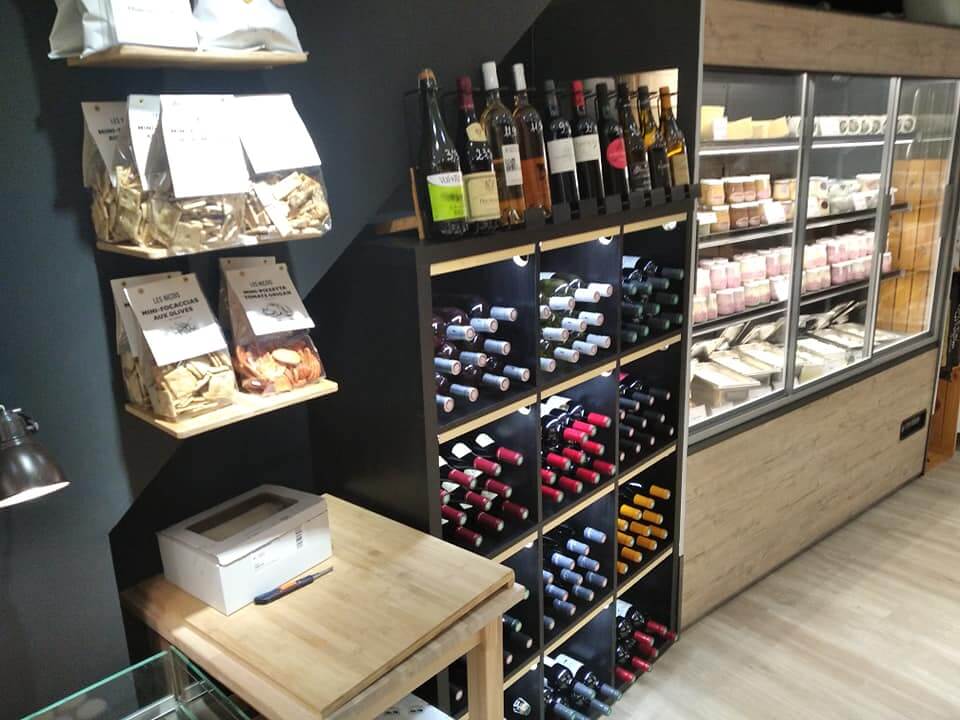 Casier à vins, étagères d'épicerie fine et vitrine murale réfrigérée dans une fromagerie