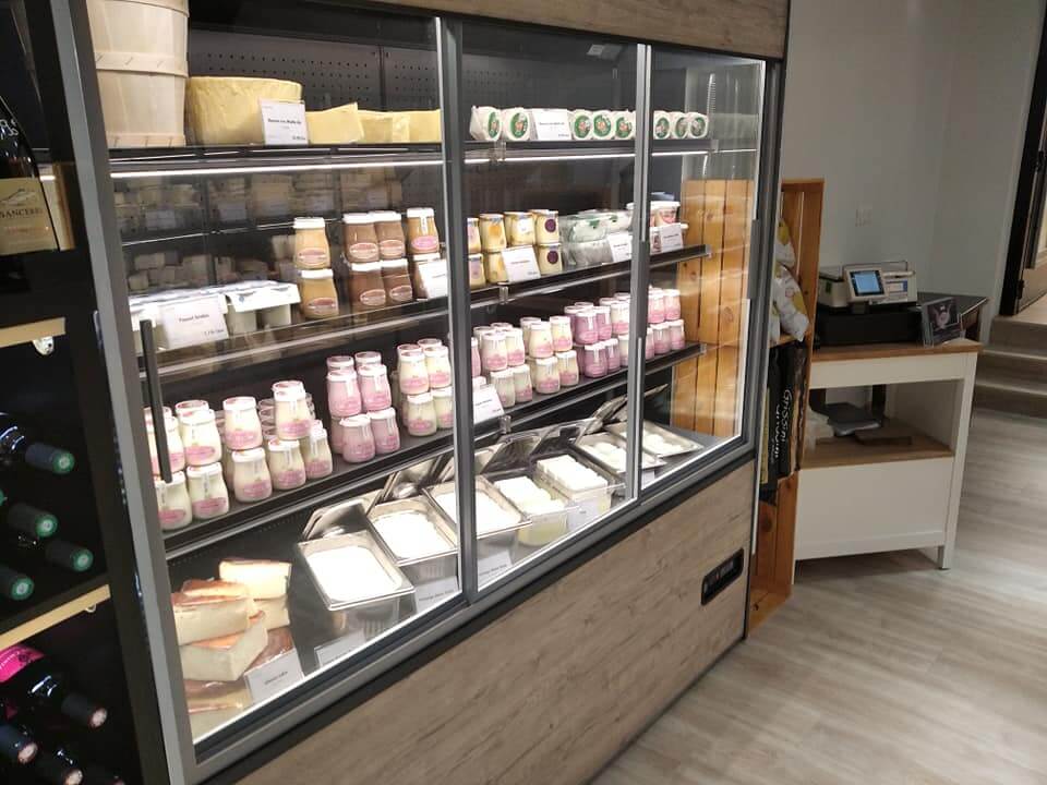 Vitrine murale réfrigérée de crèmerie avec yaourts, faisselles et produits laitiers en pots