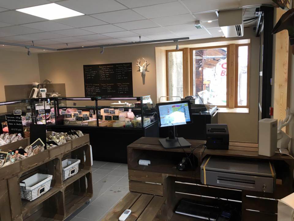Espace caisse en caisses de bois face aux vitrines réfrigérées noires de la boutique