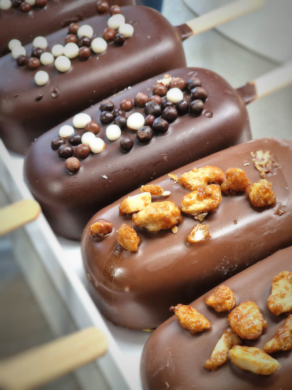 Esquimaux enrobés de chocolat garnis de perles croustillantes et de fruits secs caramélisés
