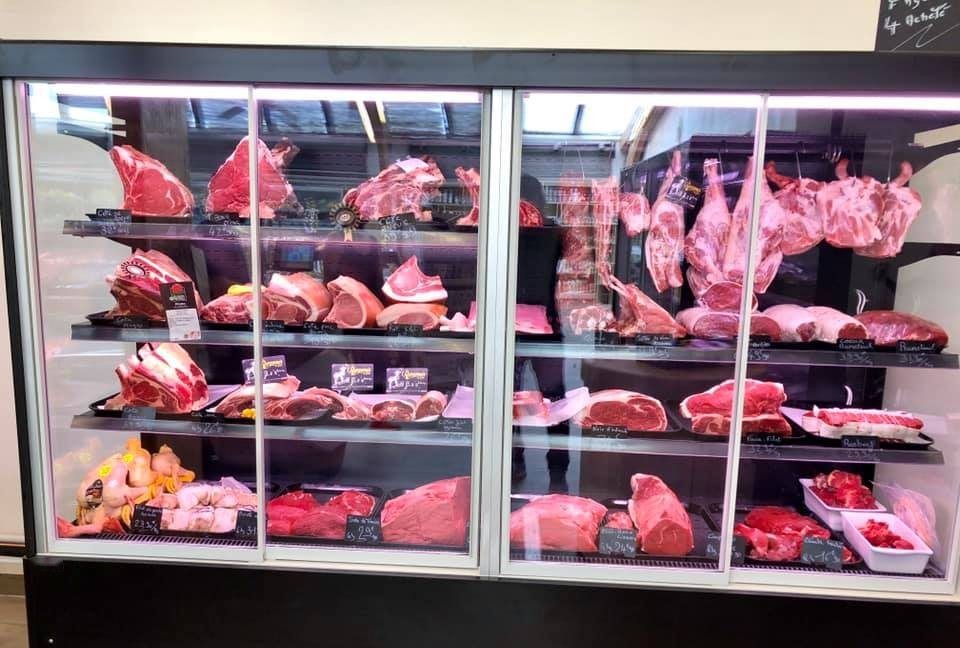 Grande vitrine murale réfrigérée à portes coulissantes garnie de côtes de bœuf et de pièces de viande