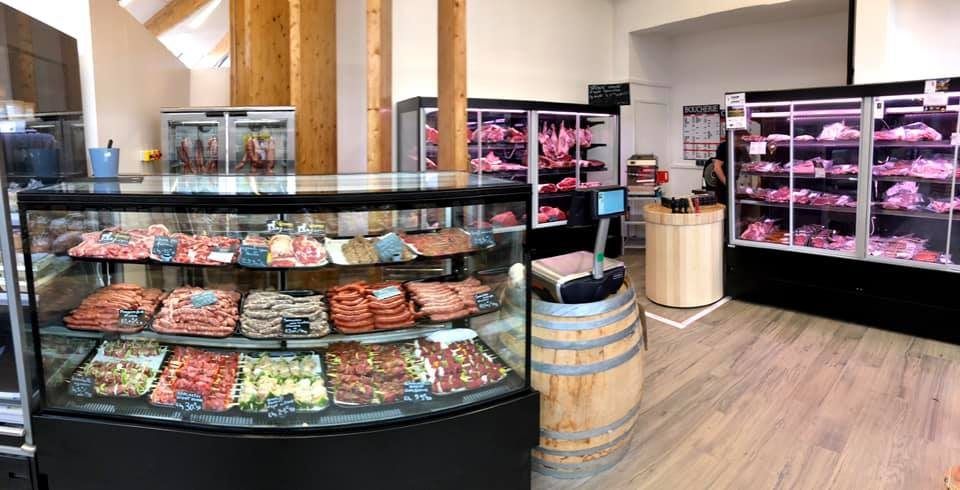 Boucherie équipée d’une vitrine réfrigérée bombée garnie de charcuterie et de murales à viande à portes vitrées