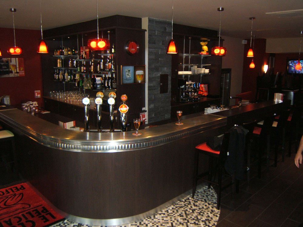 Comptoir de bar courbe avec tireuses à bière dans une brasserie de Saint-Étienne