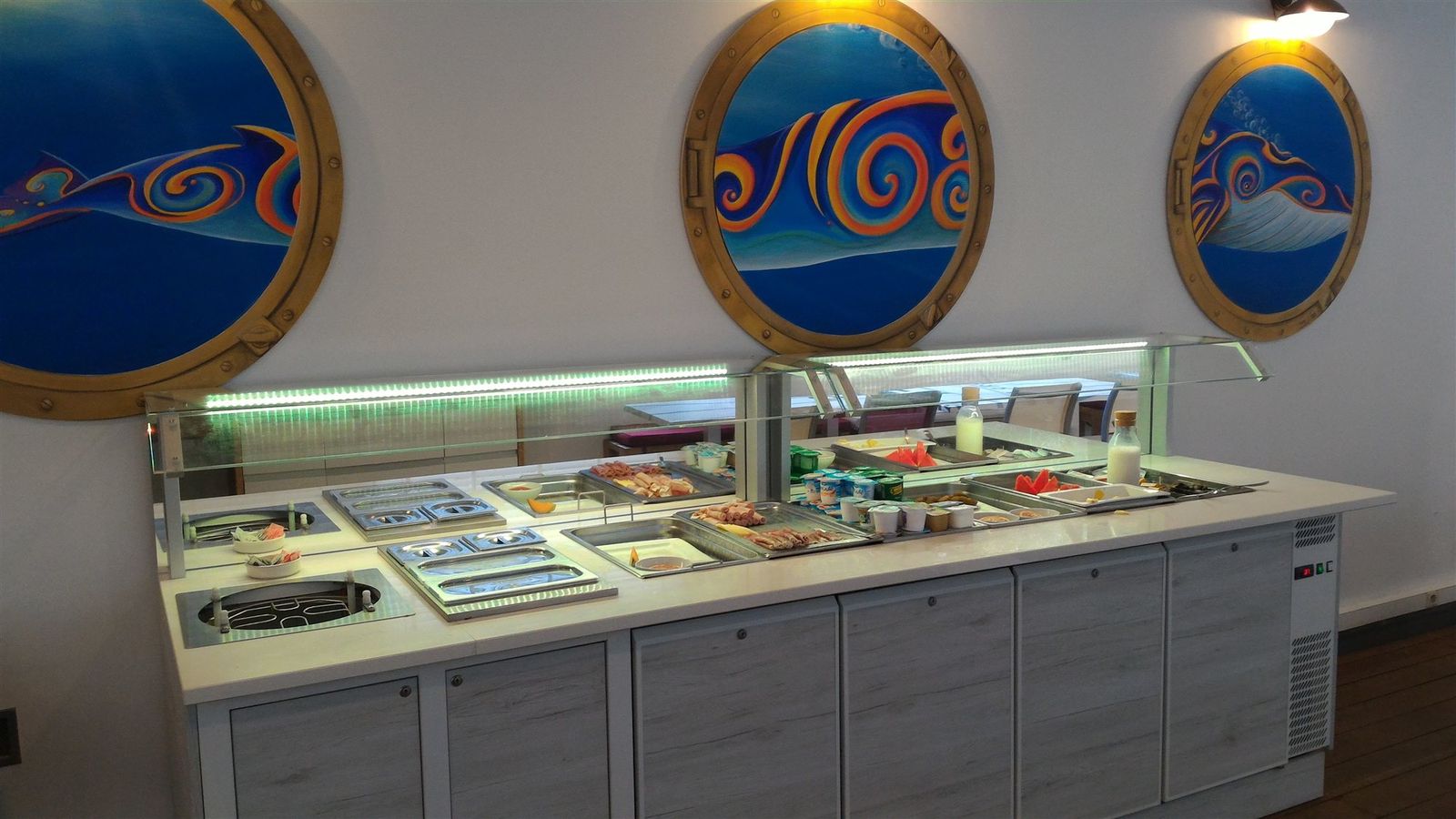 Buffet chaud et froid d’hôtel en bord de mer avec hublots décoratifs et éclairage LED