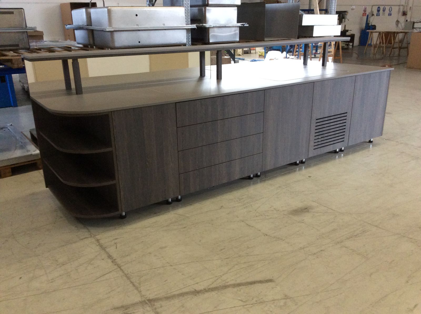Buffet de petit-déjeuner sur mesure en bois foncé avec étagère haute, en atelier avant livraison