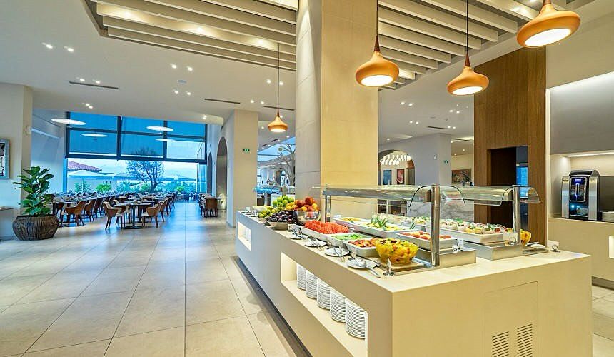 Buffet réfrigéré central dans un restaurant d’hôtel lumineux, avec salades, fruits et vitrines