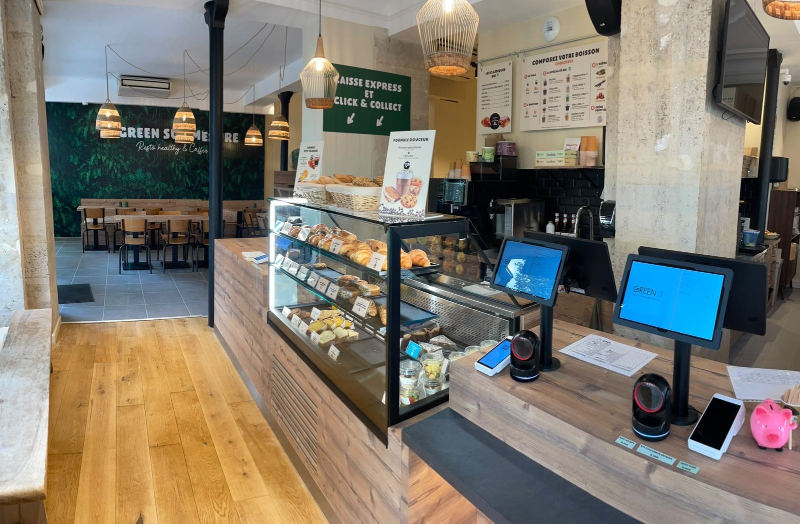 Comptoir de coffee shop à Paris : caisse, bornes de paiement et vitrine à viennoiseries en façade