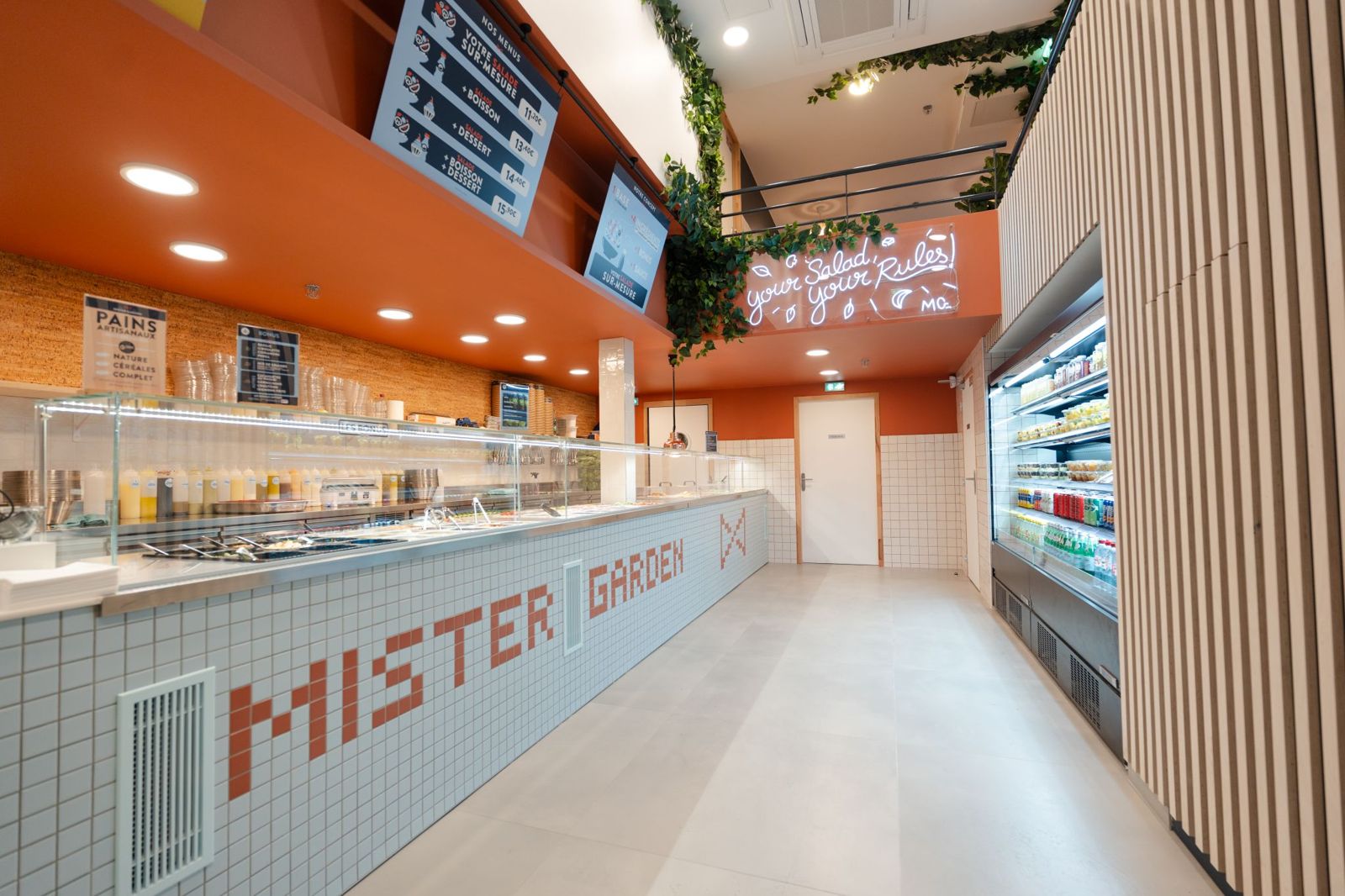 Comptoir de bar à salade habillé de carrelage avec vitrine murale libre-service à Paris