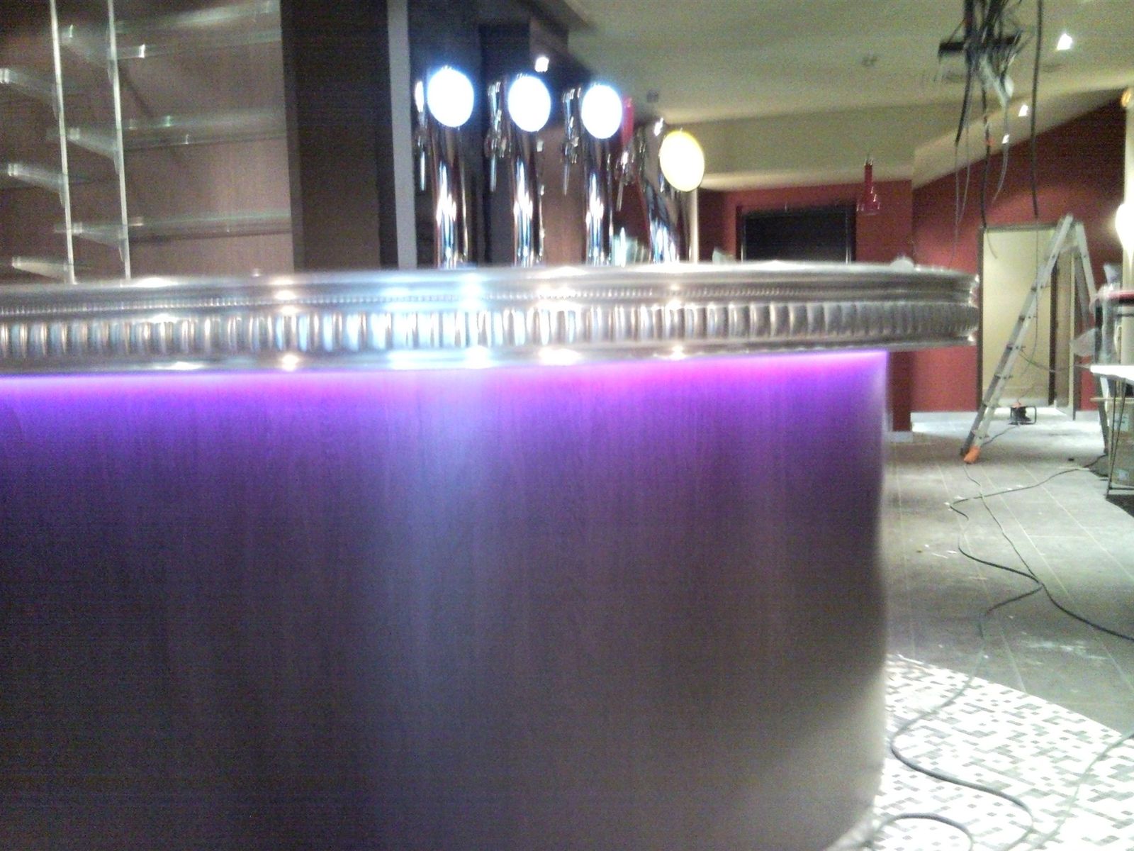 Comptoir de bar courbe avec bandeau inox et éclairage LED en soubassement