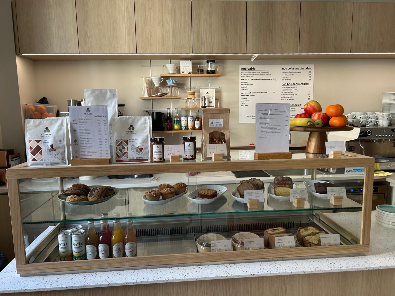 Comptoir de coffee shop avec vitrine encastrée à cadre bois et viennoiseries