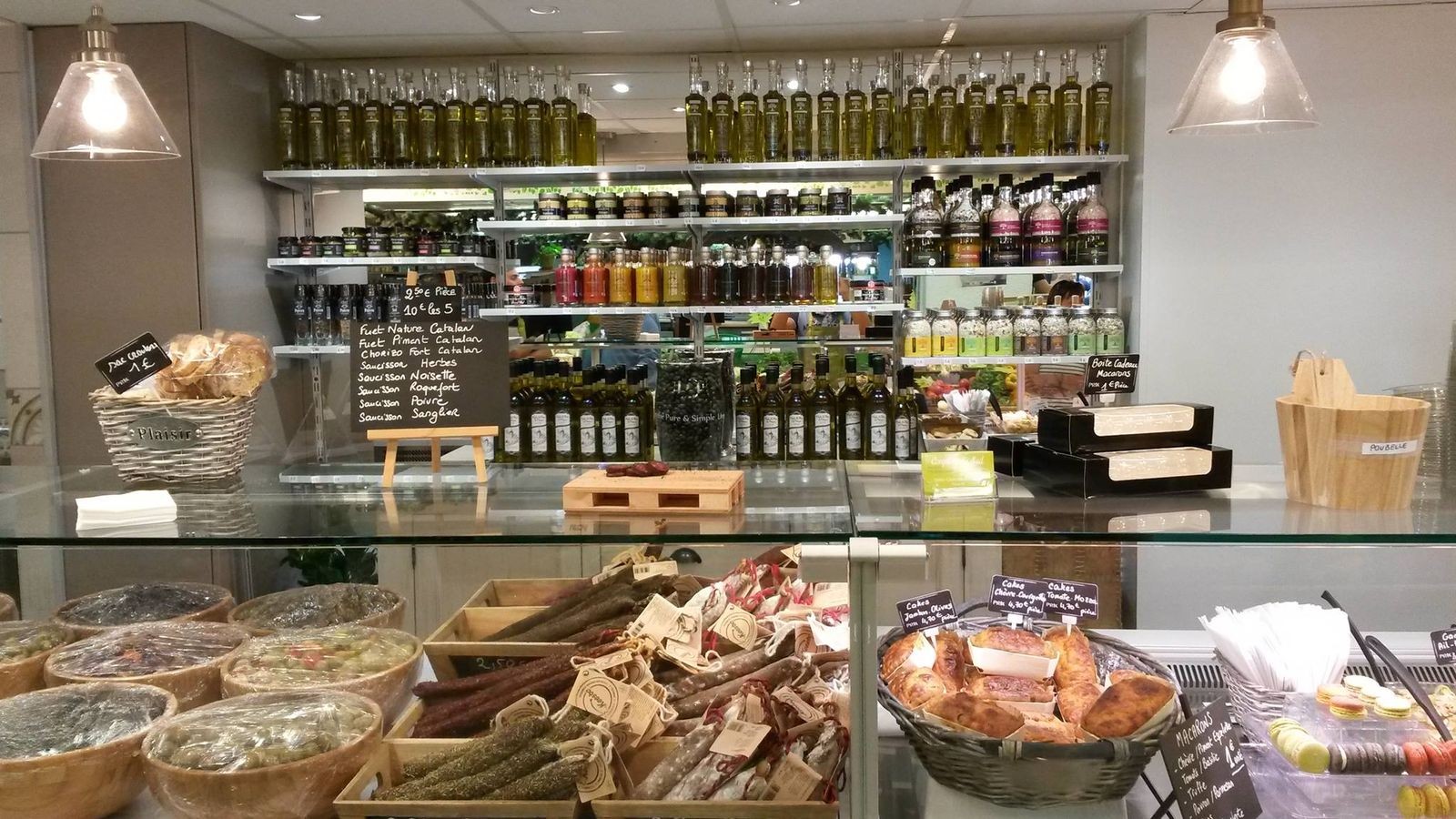 Comptoir d’épicerie provençale à Avignon avec huiles d’olive, saucissons et paniers