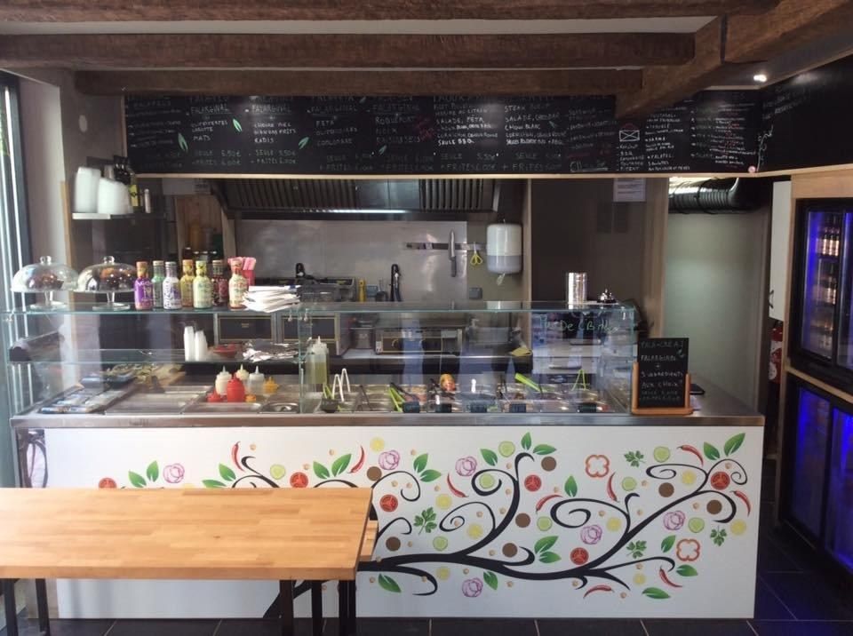 Comptoir de restaurant de falafels sur mesure avec façade décorée, vitrage et bacs de garnitures