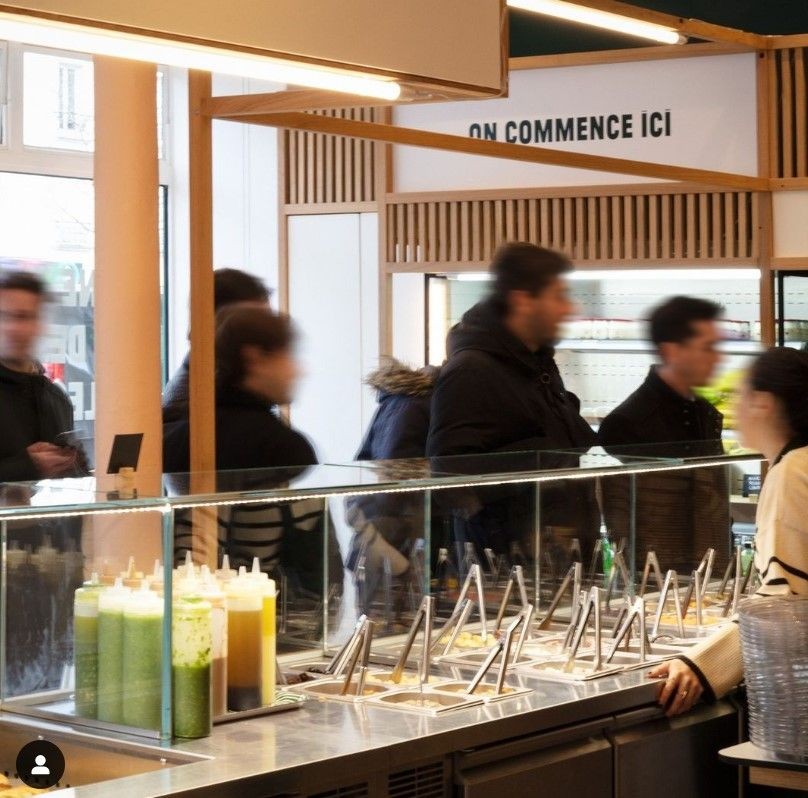 Service au comptoir d'un salad bar : composition du bol devant le client