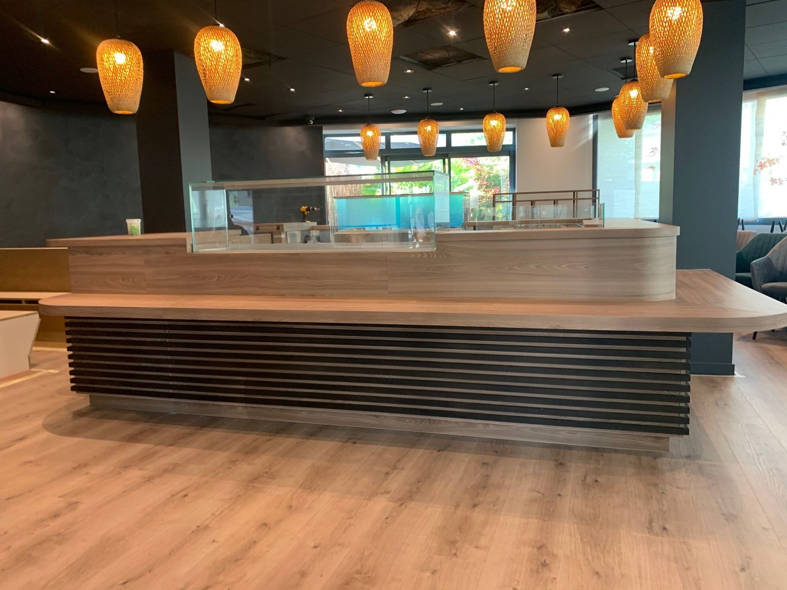 Comptoir de sushi bar en bois arrondi avec façade à lames noires