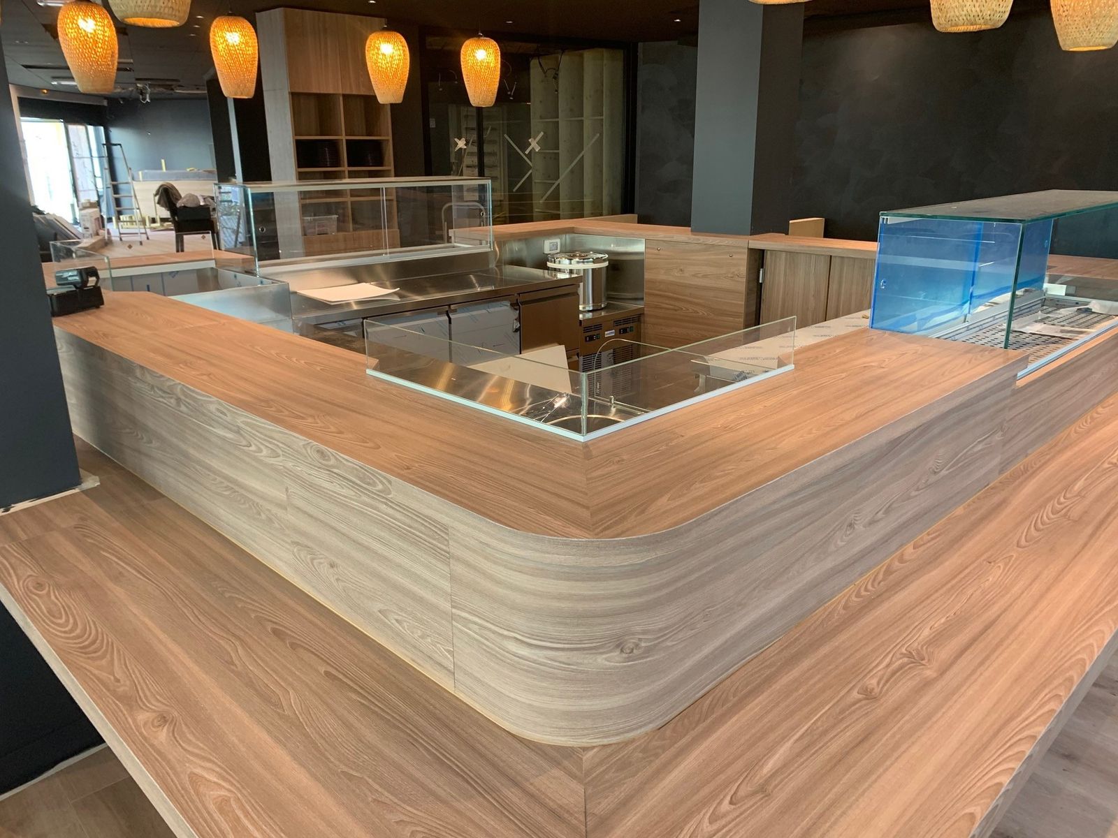 Comptoir de sushi bar en bois avec vitrines réfrigérées à poissons, vue d’ensemble