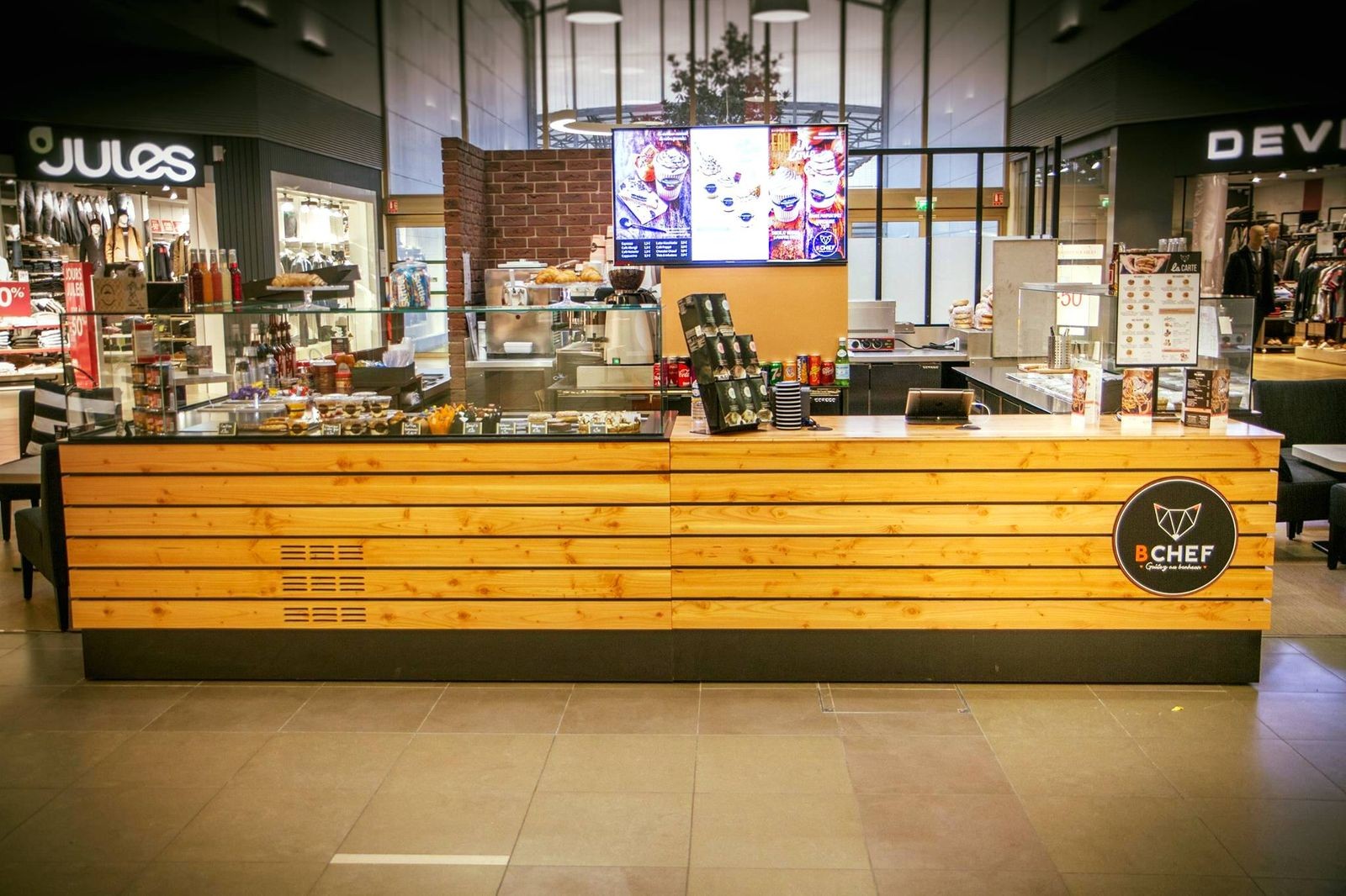 Kiosque de bagels en galerie commerciale, vue de face : comptoir bois et vitrines