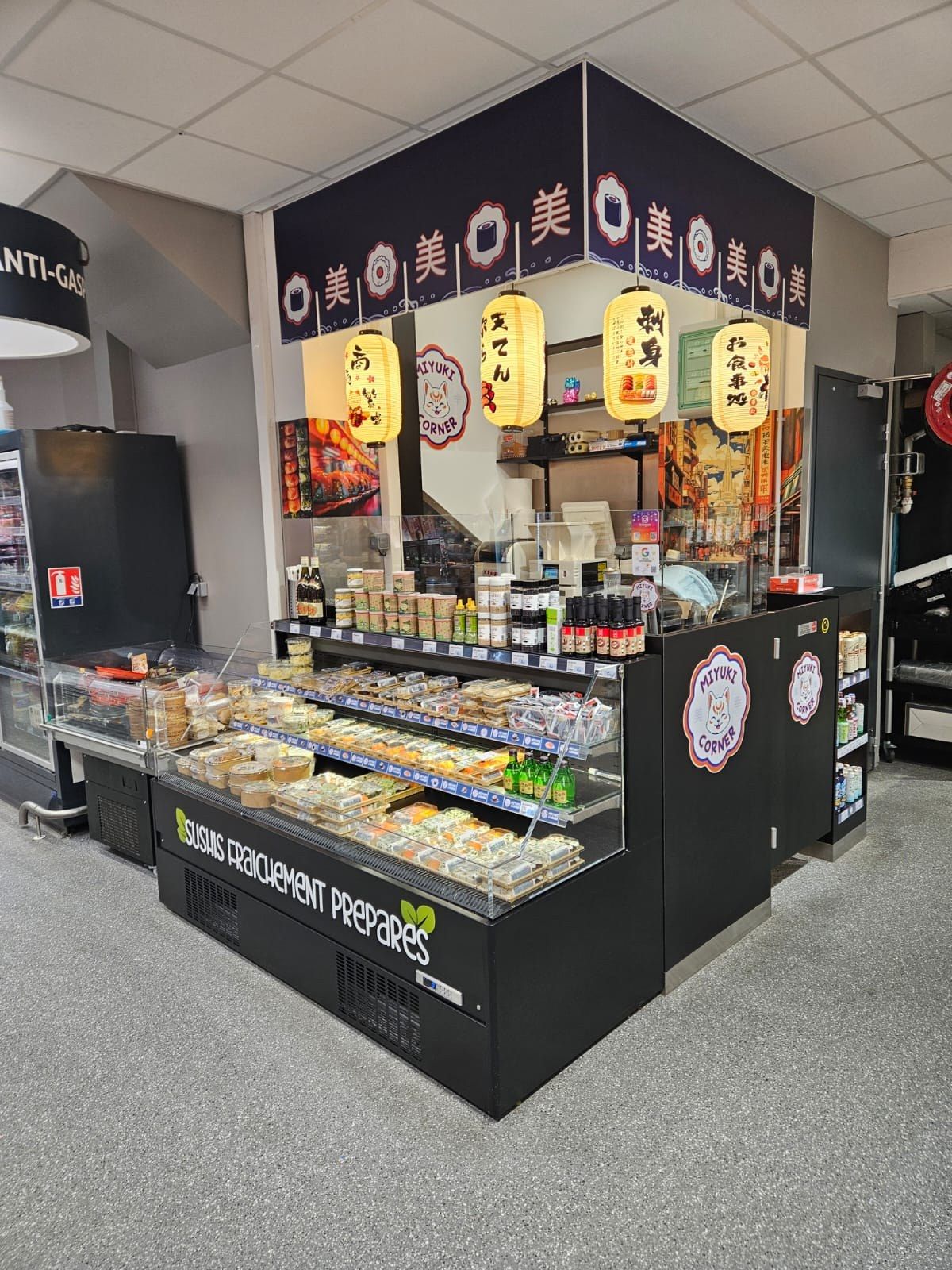 Corner sushi Miyuki en supermarché avec vitrine libre-service, lanternes et habillage noir