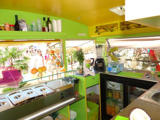 Intérieur d’une roulotte de snack : bacs réfrigérés sous vitrage, plan de travail, arrière-bar réfrigéré