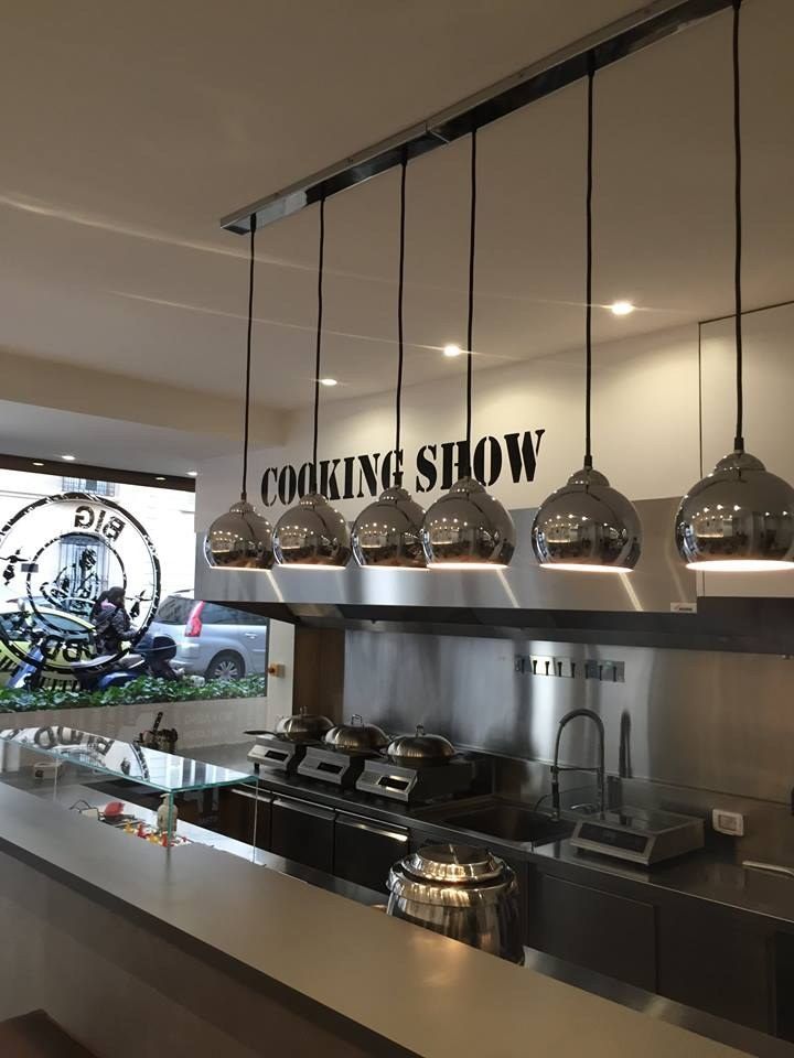 Cuisine ouverte de restaurant de wok en inox avec postes de cuisson face au client