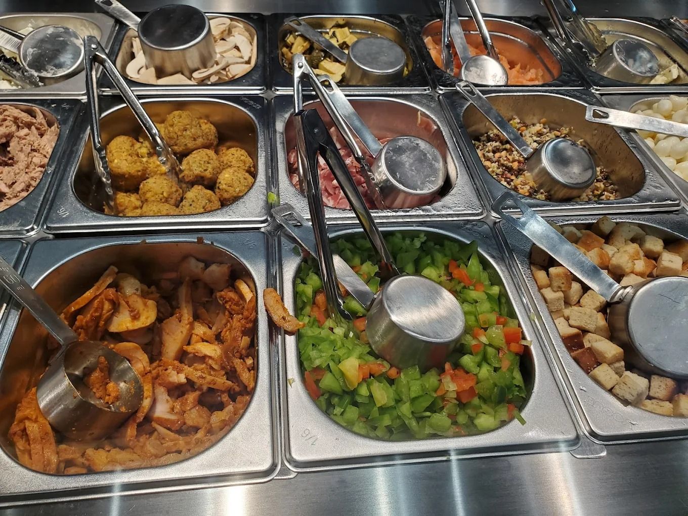 Bacs de toppings chauds et froids d’un salad bar de franchise