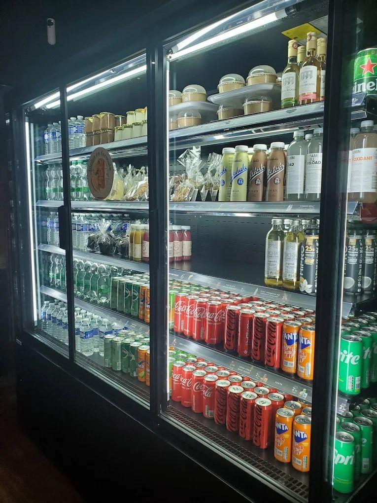 Murale réfrigérée à portes vitrées garnie de boissons et de desserts dans un restaurant de franchise