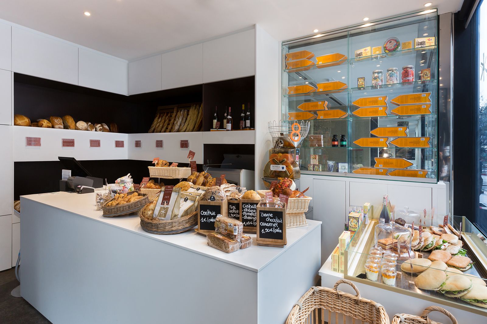 Espace petit-déjeuner d’hôtel avec îlot de pains et viennoiseries et vitrine murale