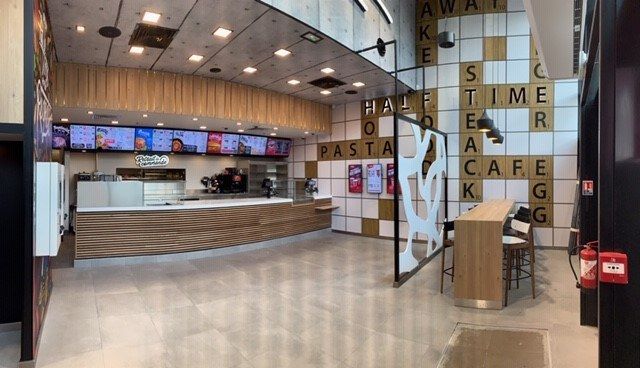 Salle du fast-food Halftime avec long comptoir de commande à lames bois