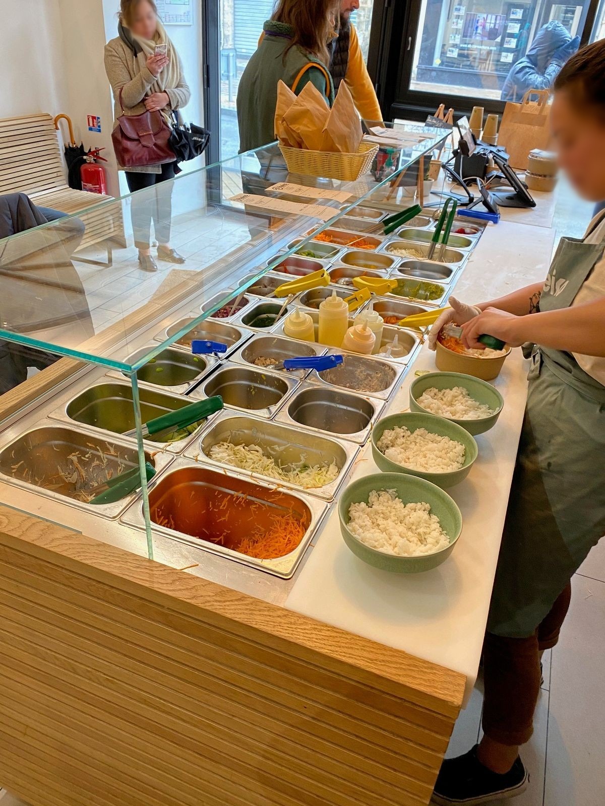 Comptoir de composition de bowls à bacs GN réfrigérés sous vitrage dans un restaurant de franchise
