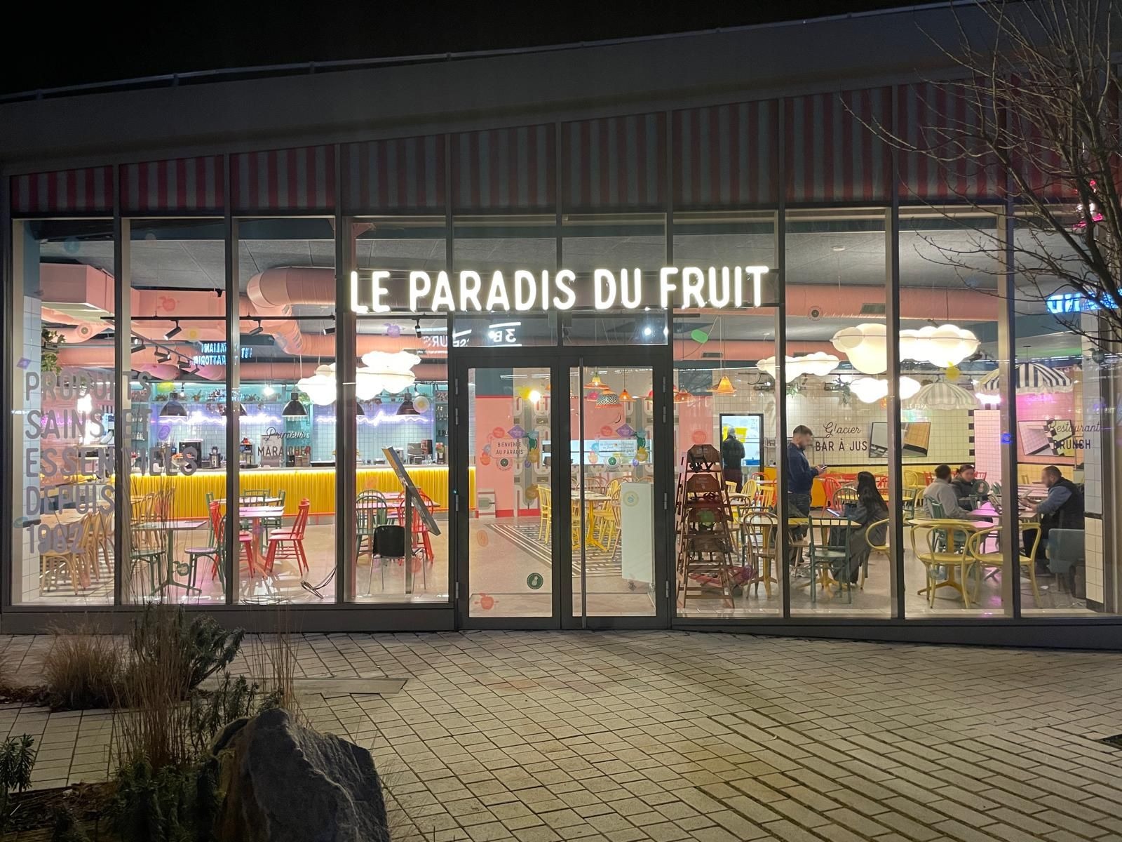 Façade illuminée d’un restaurant Le Paradis du Fruit