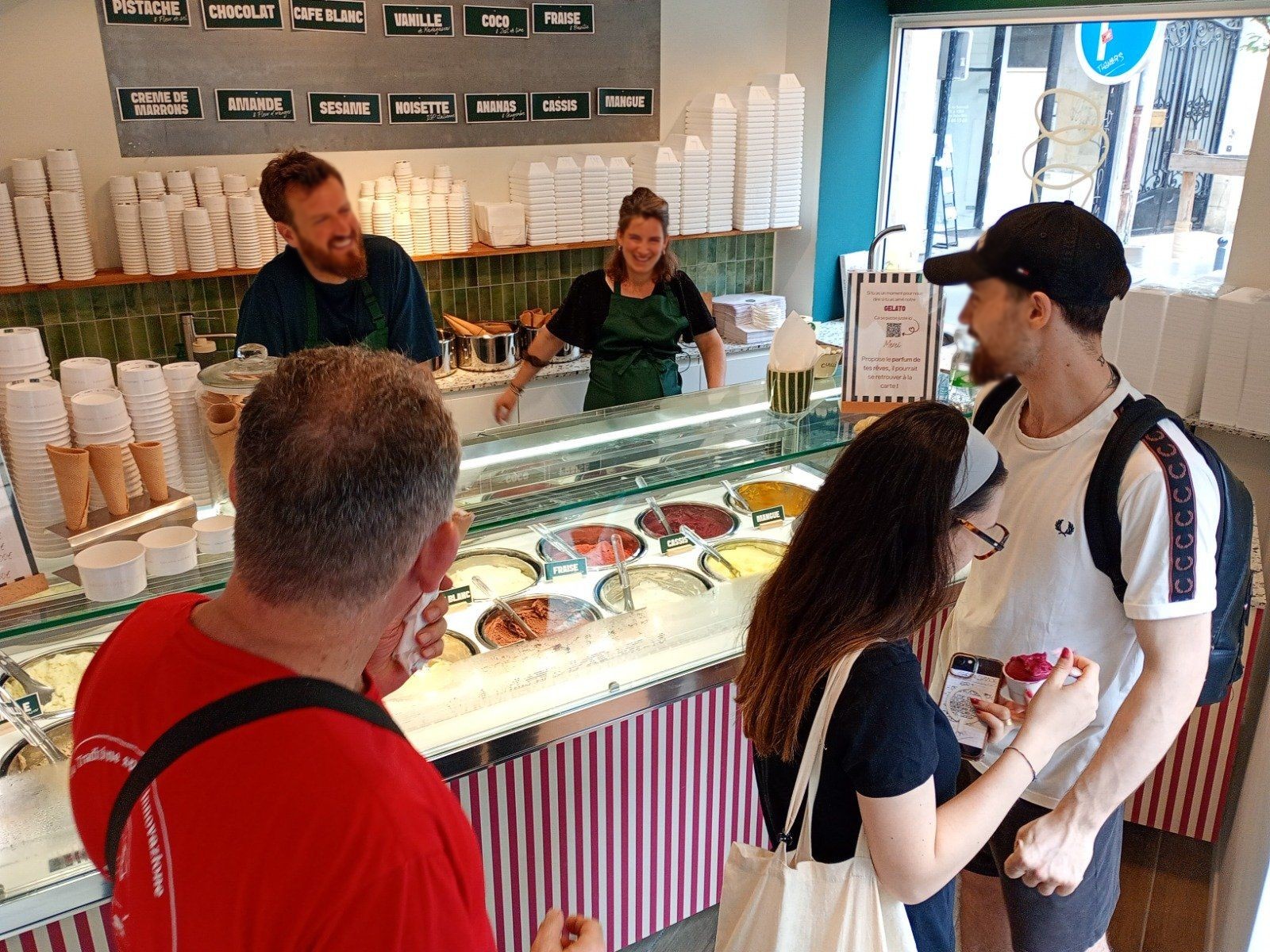 Agencement de glacier : glacier artisanal à Bordeaux : clients devant la vitrine à glaces à carapines, artisans au service