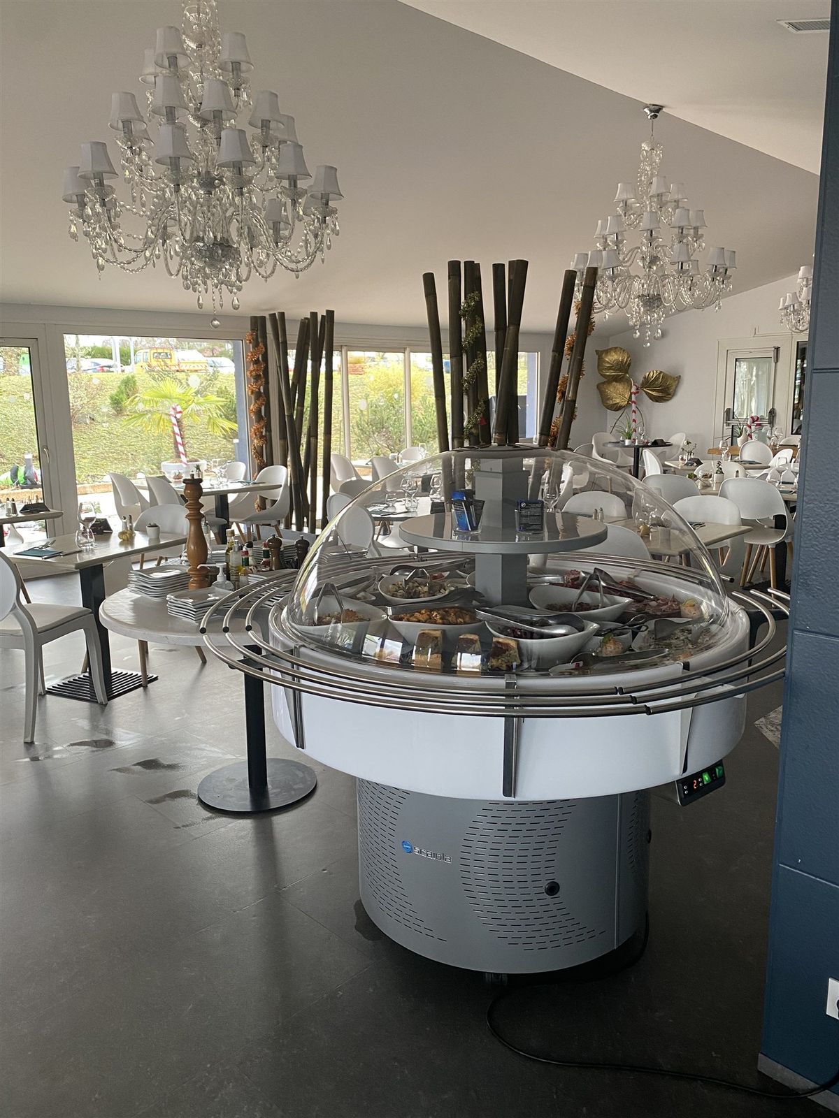 Îlot de buffet rond réfrigéré au centre d’une salle de restaurant d’hôtel avec lustres