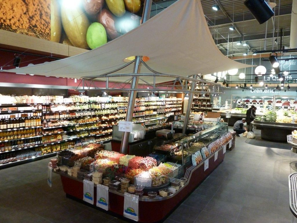 Kiosque à olives et fruits secs en grande surface avec voile d’ombrage