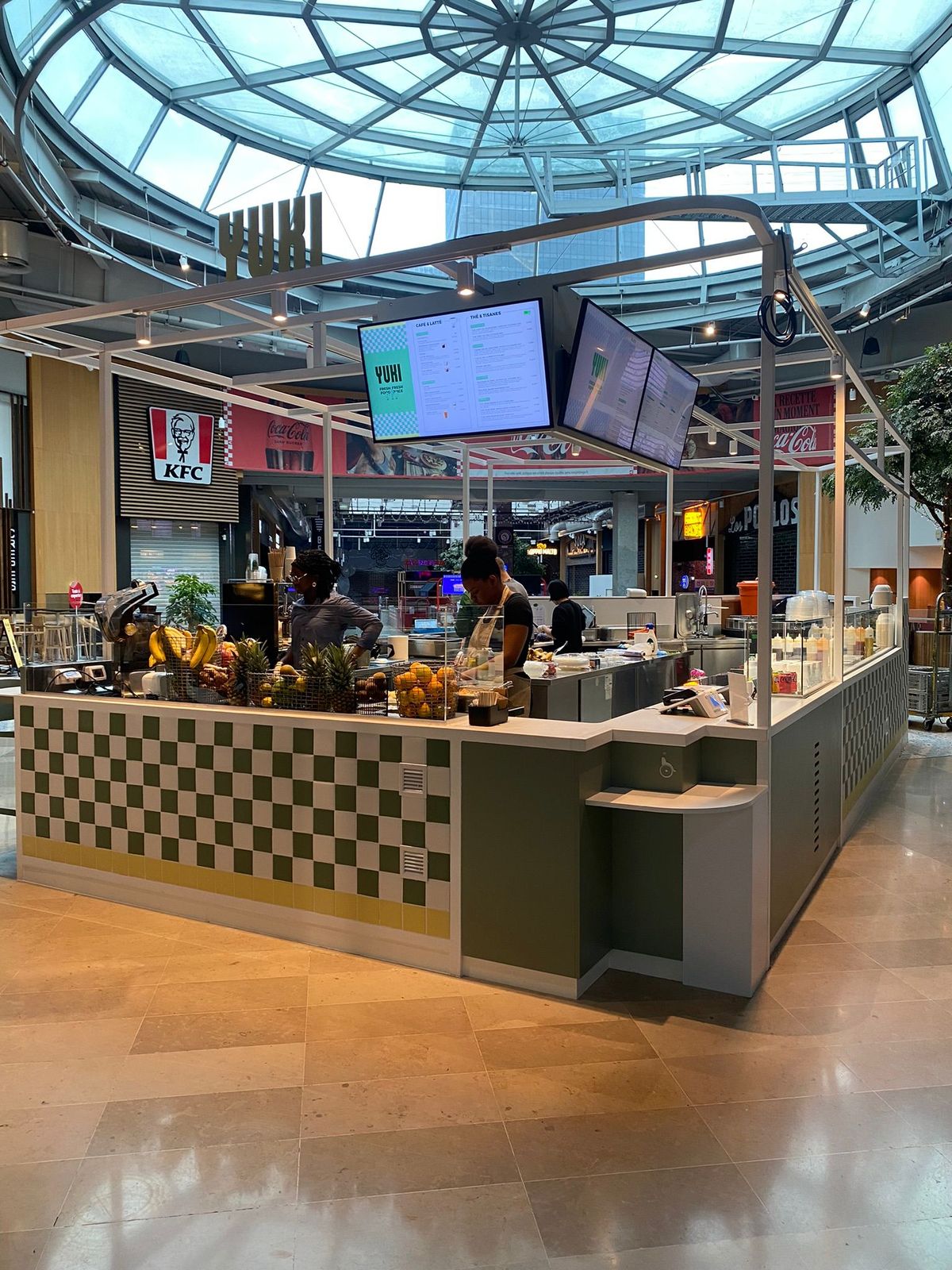 Kiosque sur mesure à structure métallique blanche et écrans sous une verrière de centre commercial
