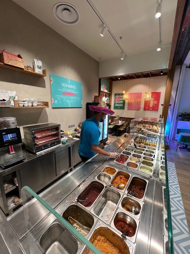 Ligne de préparation de burritos avec bacs chauds et froids devant le client