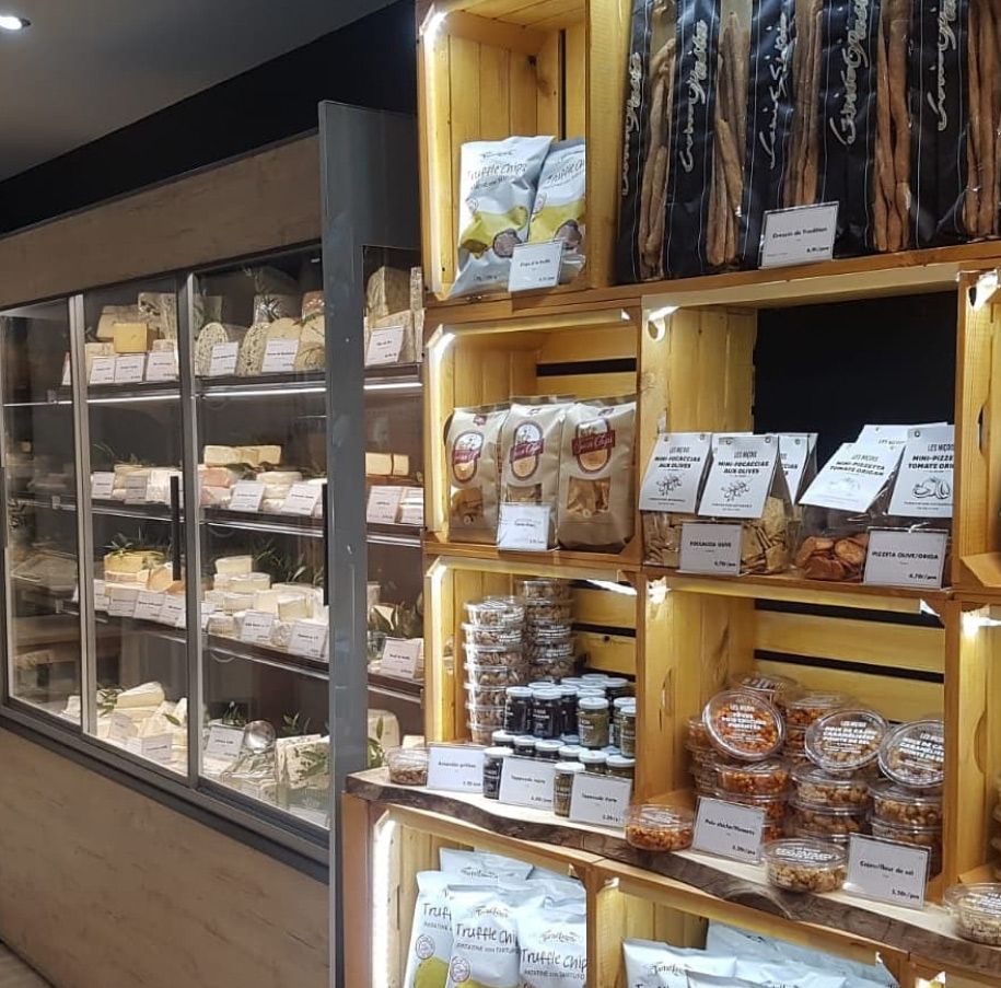 Murale réfrigérée à fromages et étagères d’épicerie fine en caisses de bois à la Fromagerie Métin