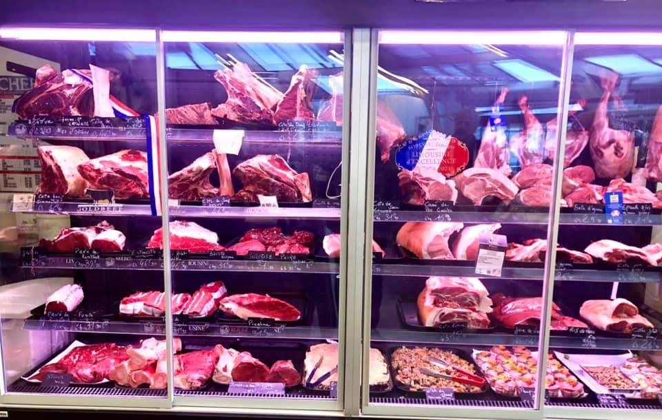 Murale réfrigérée à portes vitrées exposant pièces de bœuf, agneau et préparations en boucherie