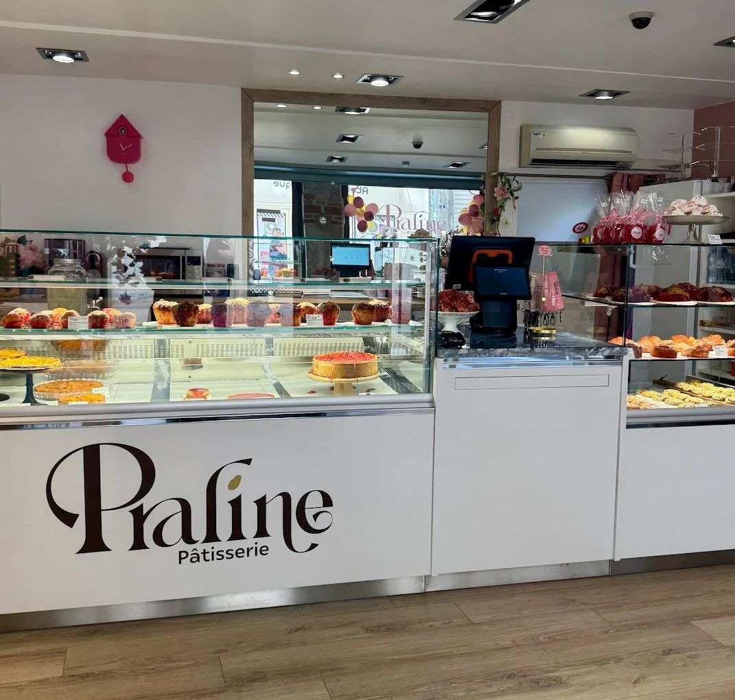 Comptoir blanc et vitrines réfrigérées de la pâtisserie Praline à Vienne