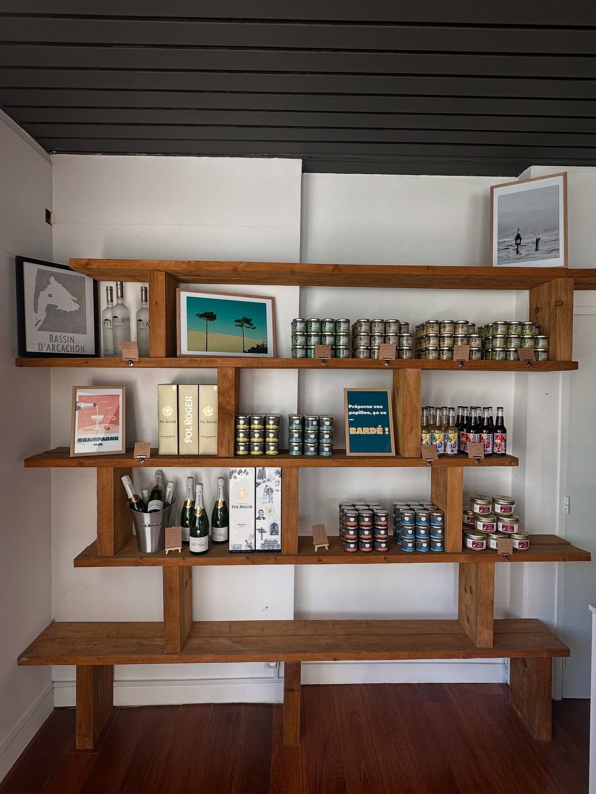 Étagères en bois d’épicerie de la mer avec conserves, vins et champagnes