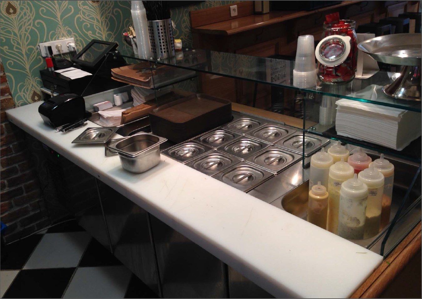 Poste de dressage de burgers avec bacs GN, sauces et caisse sur plan blanc