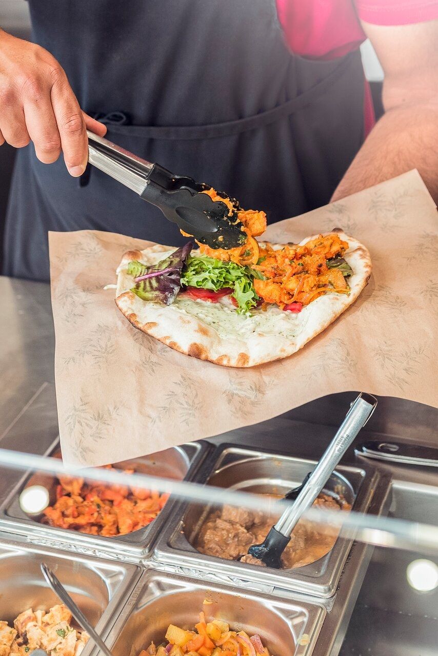 Préparation d’un naan garni devant le client à partir de bacs chauds