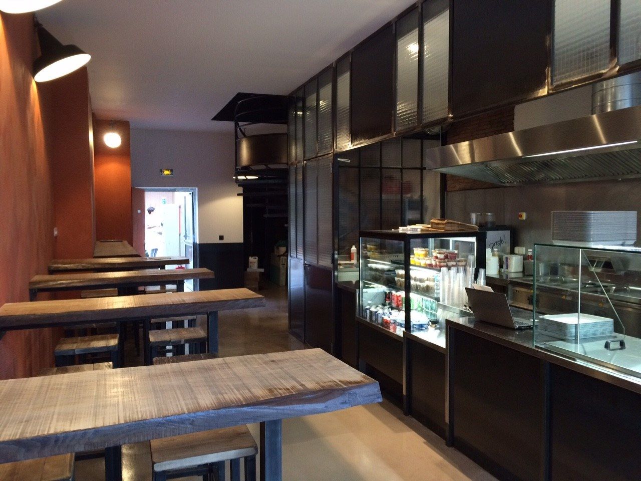 Restaurant de falafels avec vitrine réfrigérée, comptoir et tables en bois massif