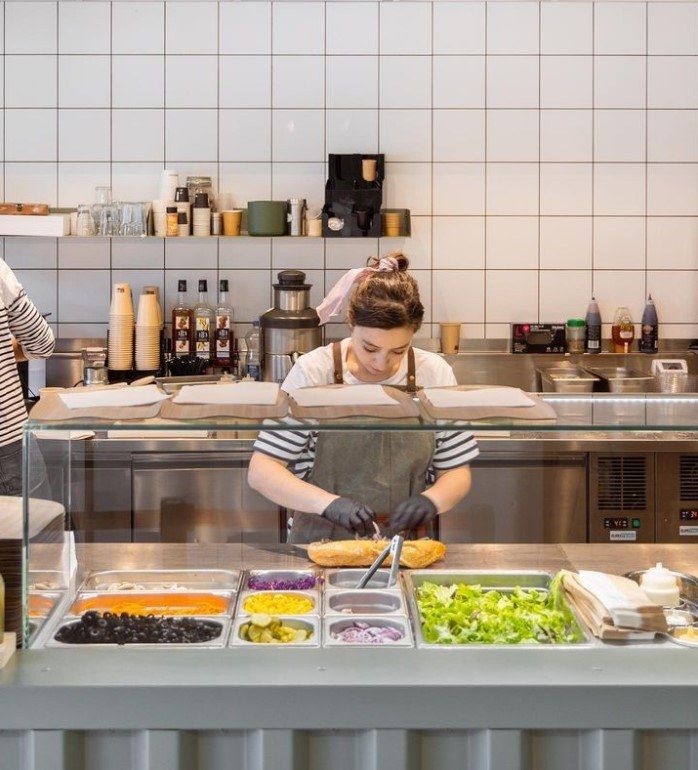 Préparation de sandwichs devant le client au comptoir réfrigéré de La Mandarine à Nancy