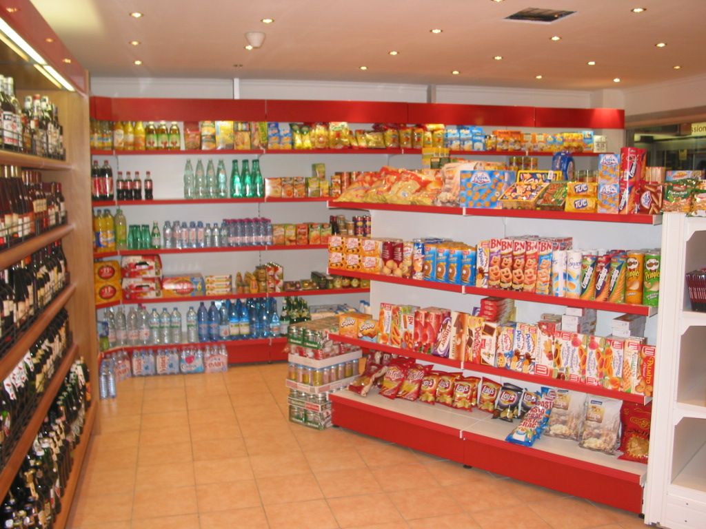 Rayons d’épicerie et de boissons dans une boutique de gare, gondoles rouges et blanches
