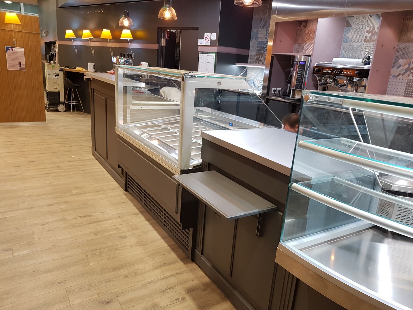 Vitrine réfrigérée en libre-service avec glissière à plateau devant un comptoir