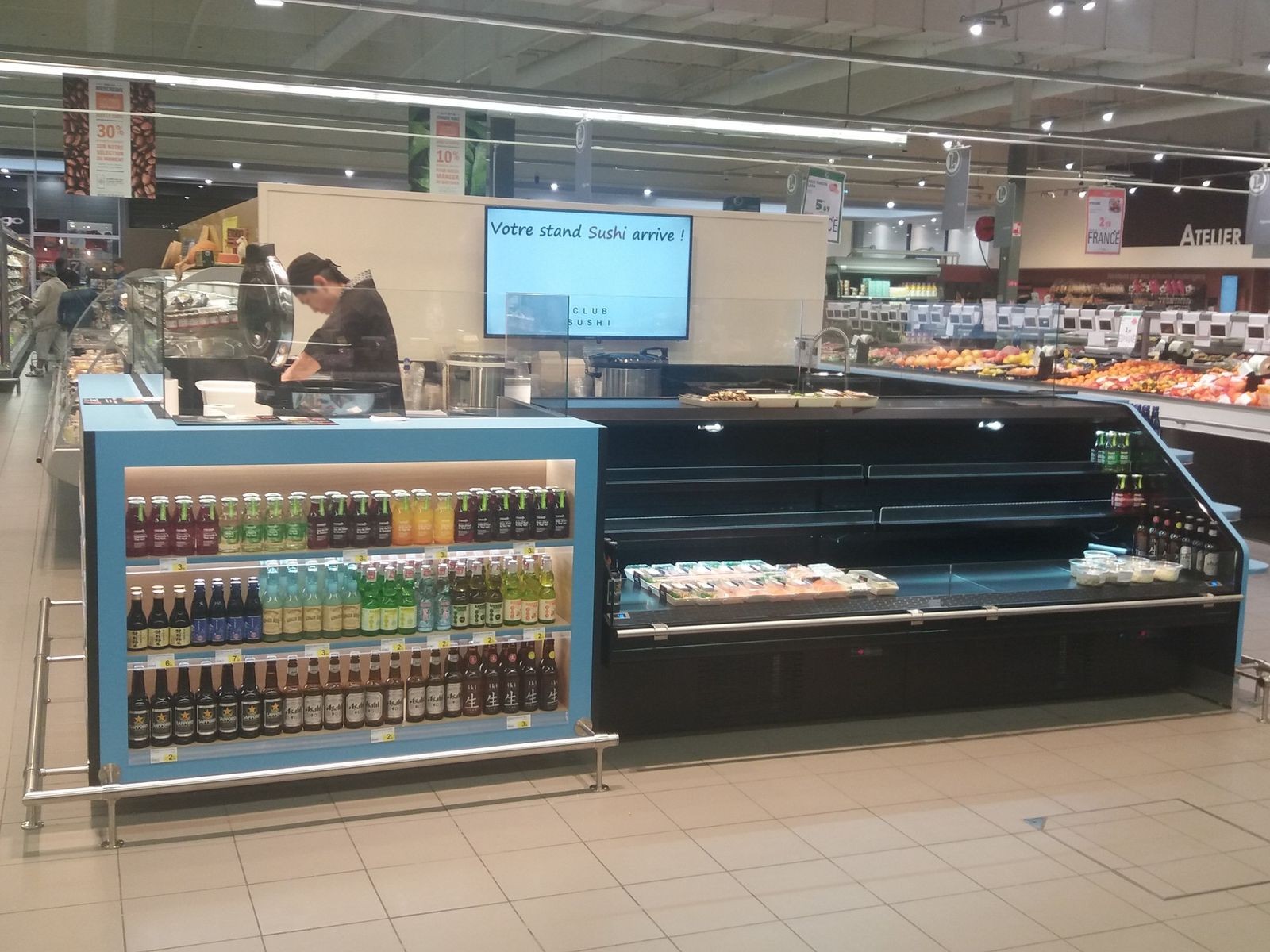 Stand de sushis en hypermarché avec vitrine libre-service et étagère à boissons bleue