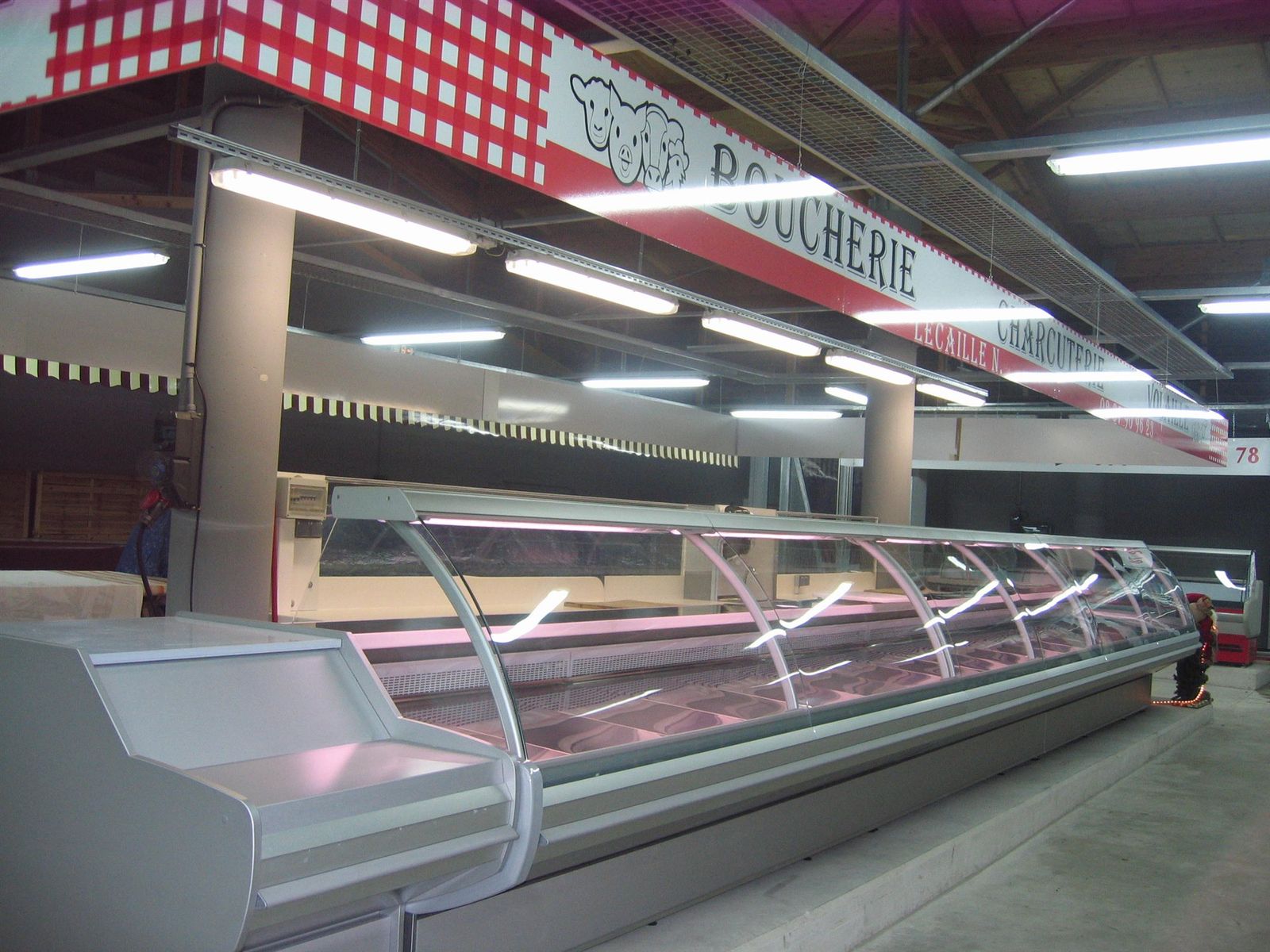 Vitrine de boucherie à vitrage bombé de grande longueur dans une halle de marché