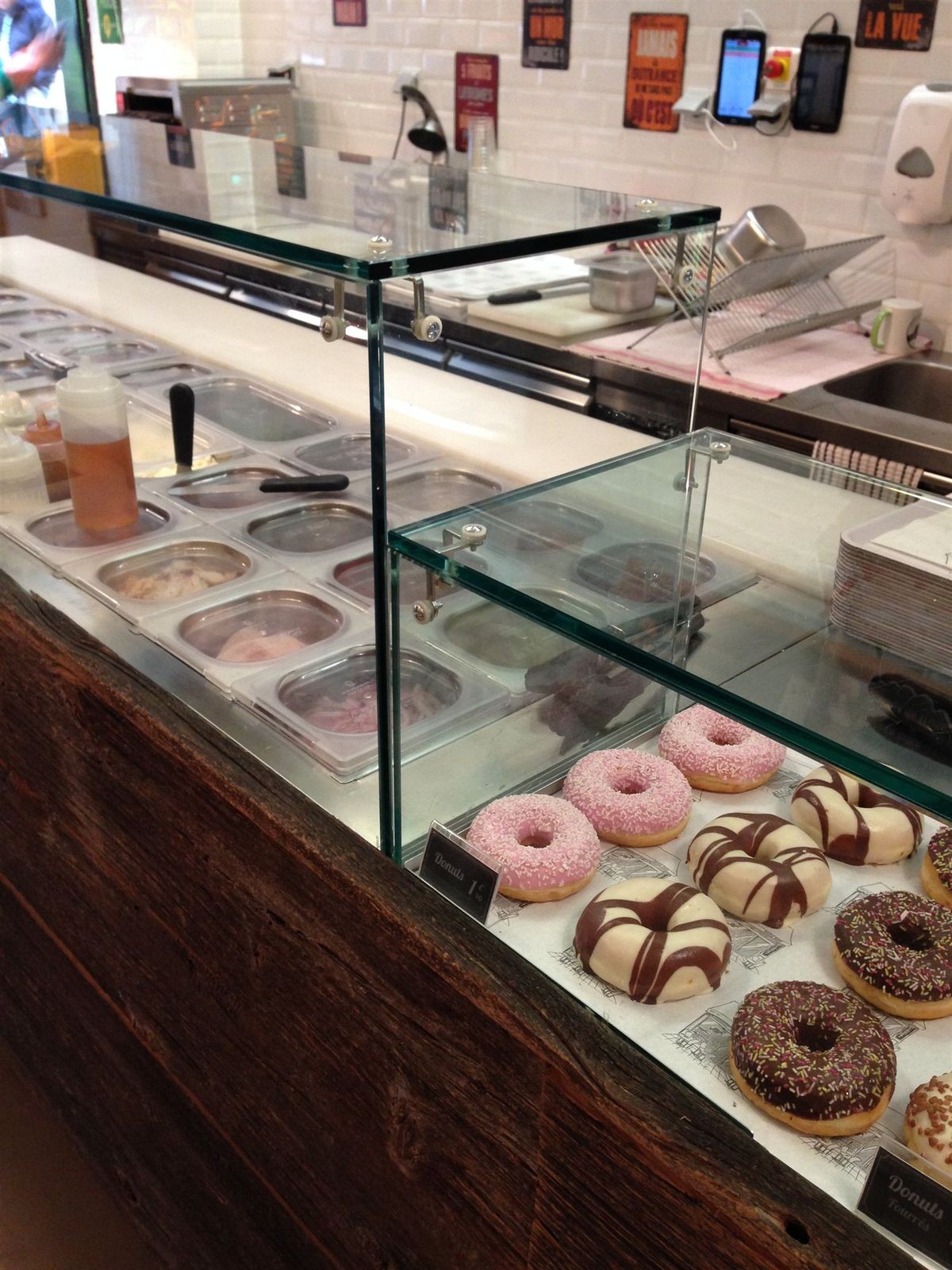 Vitrine à donuts sur un comptoir de bagel shop habillé de bois