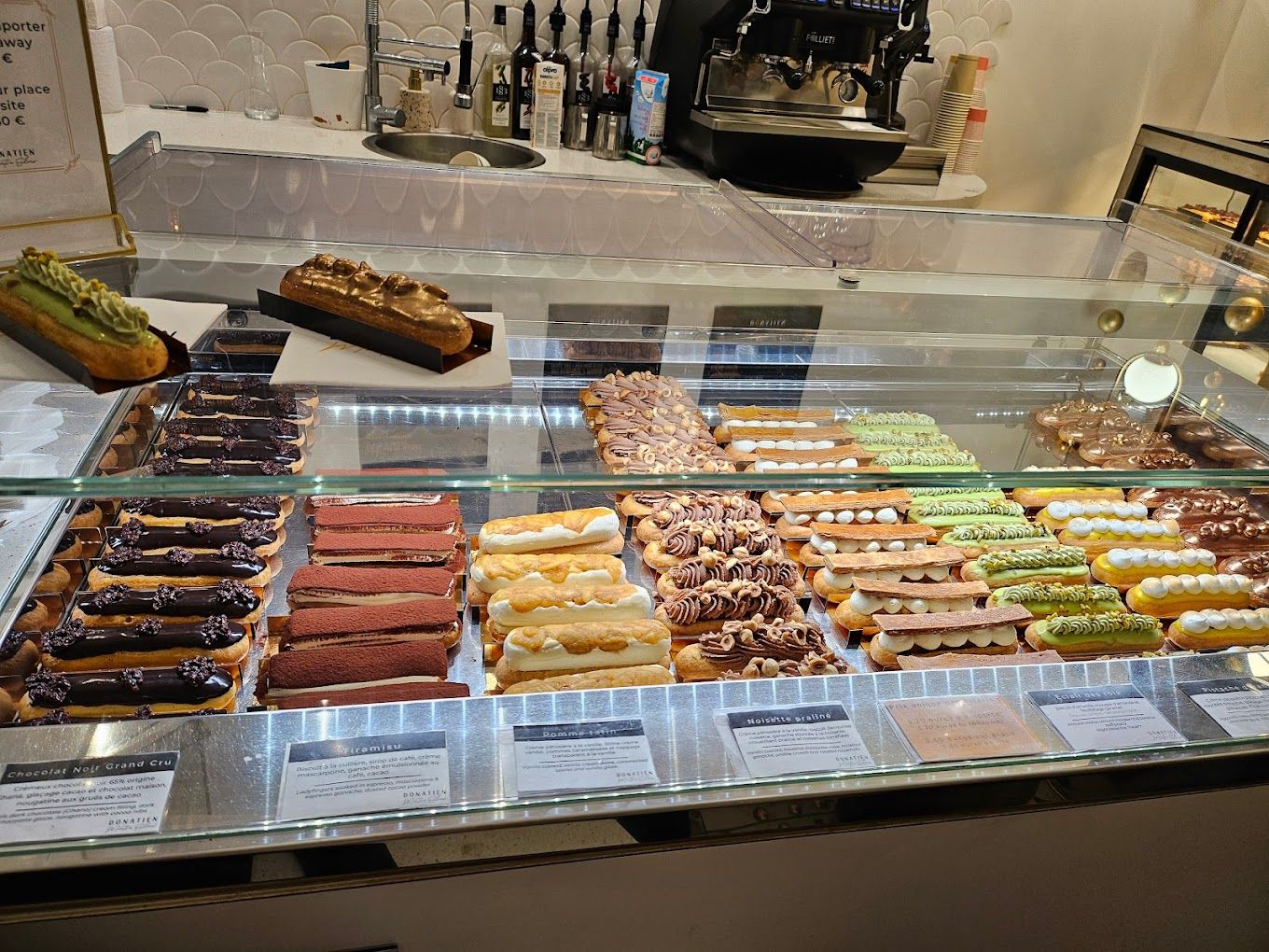 Vitrine réfrigérée garnie d’éclairs colorés dans une pâtisserie artisanale