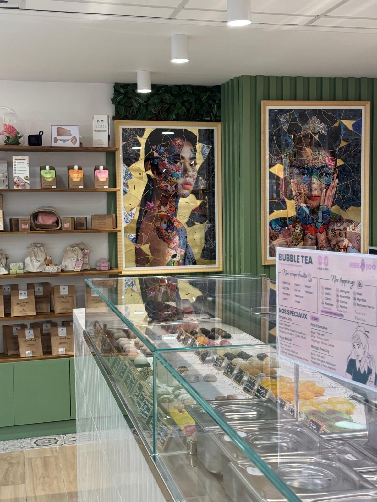 Vitrine réfrigérée à mochis et comptoir de bubble tea dans une boutique aux murs verts