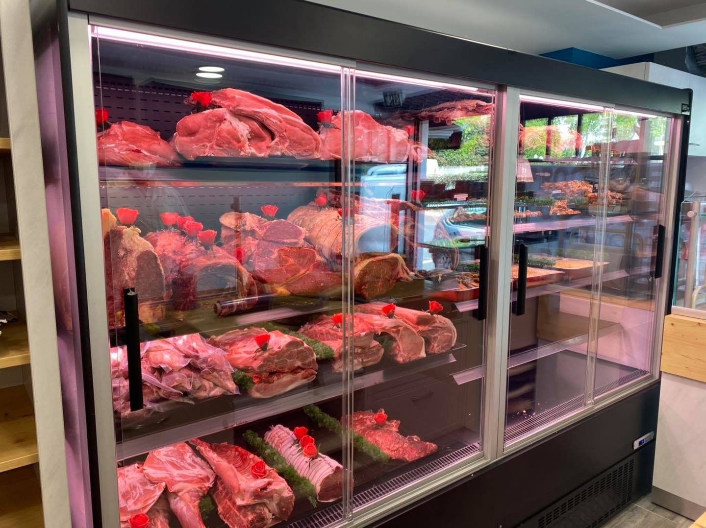 Vitrine murale réfrigérée à portes vitrées présentant des rôtis et des pièces de bœuf